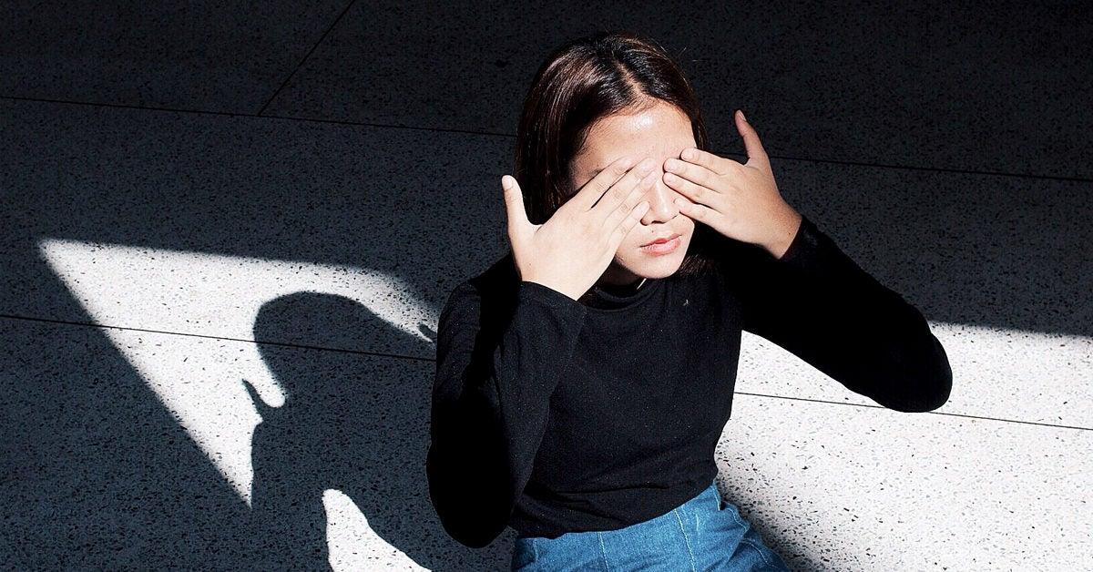 Persona cubriéndose los ojos ante la luz intensa del sol por fotofobia